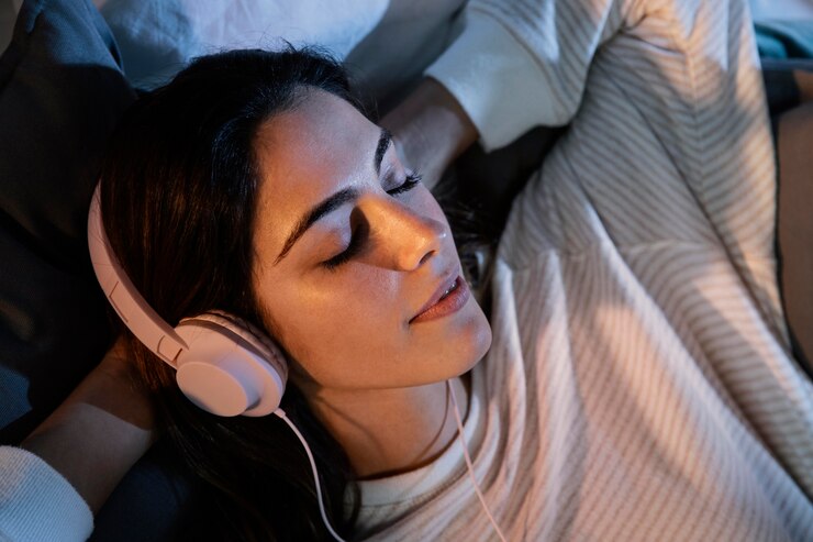 woman-using-headphones-music-home-bed